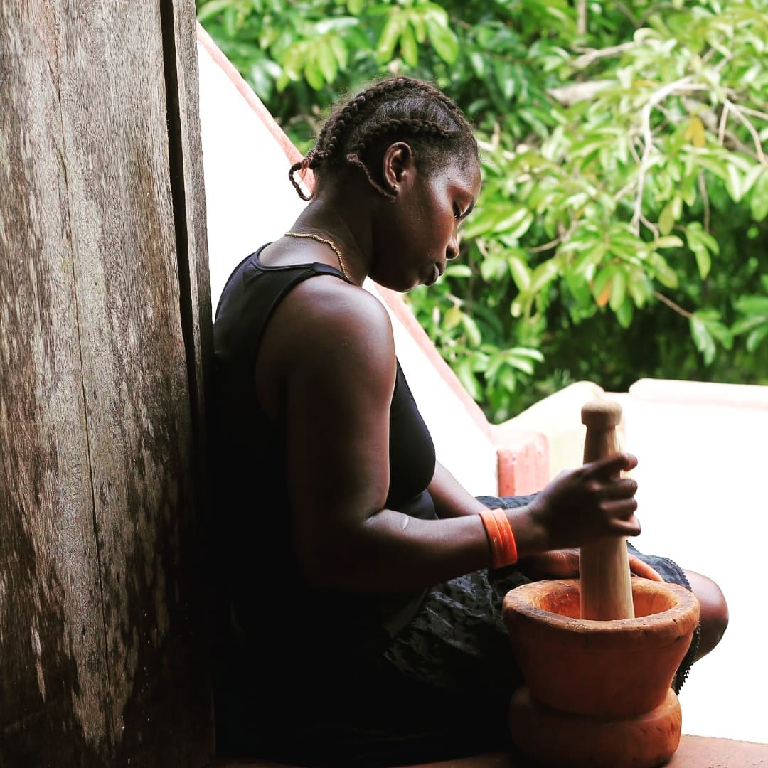 mujer moliendo cacao